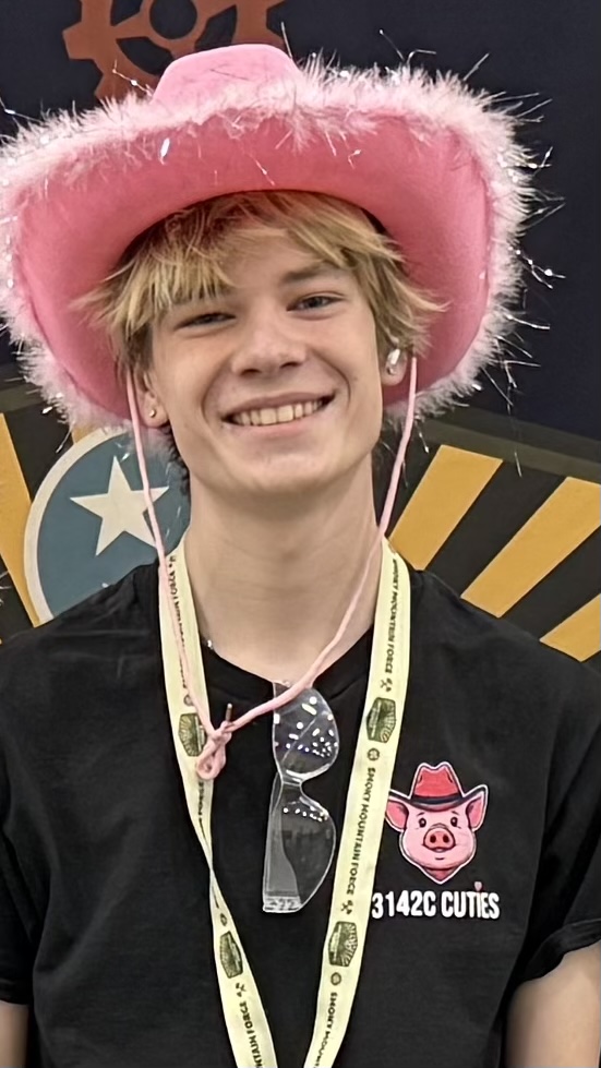 Henry Van Ness wearing a Scoutly team shirt at a robotics event